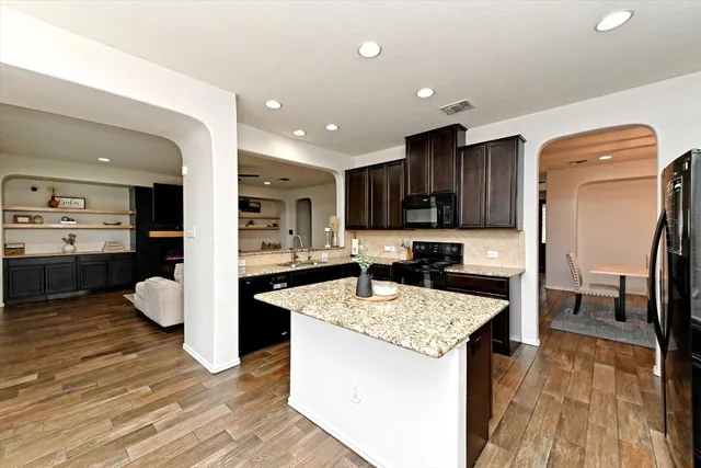 a kitchen with granite countertop kitchen island wooden cabinets stainless steel appliances and center island