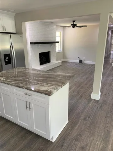 a kitchen with granite countertop a sink and a refrigerator