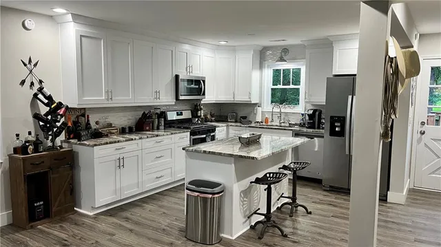 a kitchen with a sink a stove a refrigerator and cabinets
