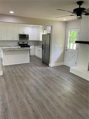 a kitchen with stainless steel appliances granite countertop a refrigerator and a stove top oven