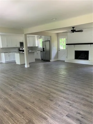 a view of empty room with wooden floor and fireplace