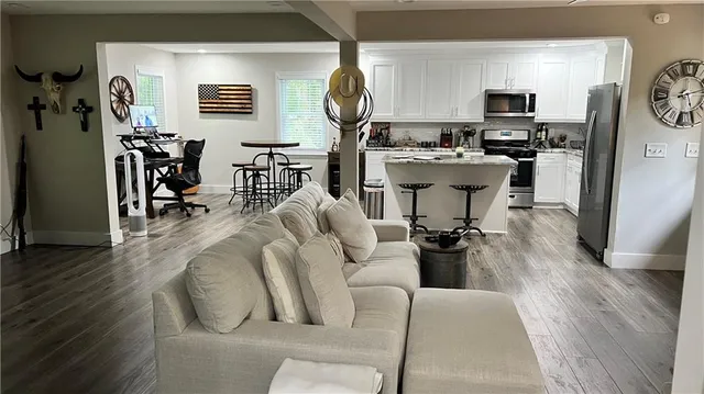 a living room with furniture a wooden floor and a large window