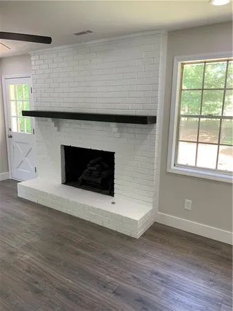 a living room with a fireplace and a floor to ceiling window