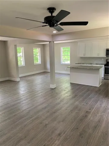 a view of an empty room with a window and wooden floor
