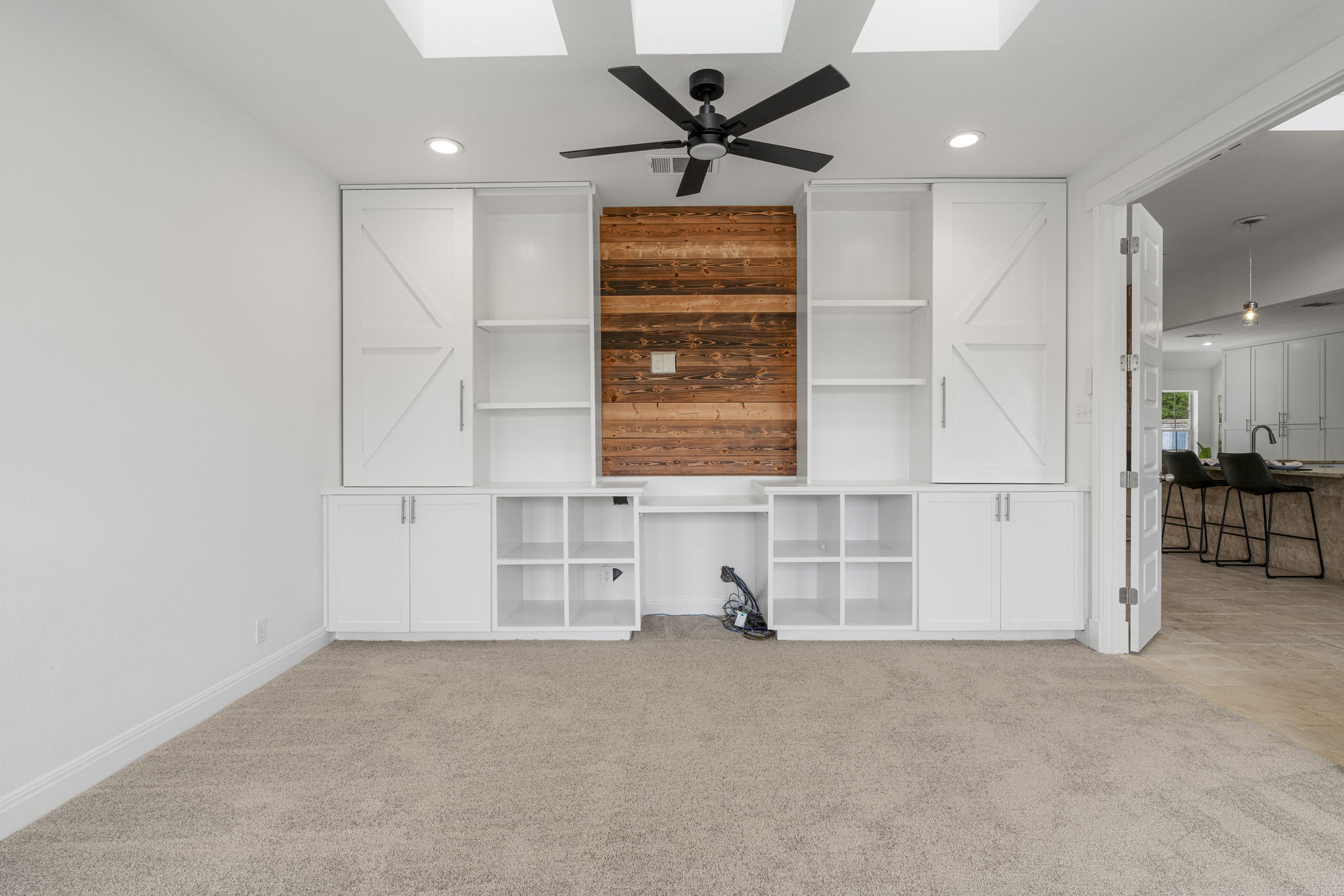 1129 Cedar Pass Road Driftwood, TX 78619 - Photo 18 of 40 Check out the custom built-ins—they feature barn-door style sliders and a warm wood accent that ties back to the rustic theme of the house.