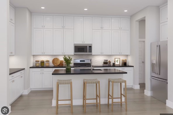 26239 Prairie Delight Place Hockley, TX 77447 - Photo 2 of 7 a kitchen with granite countertop white cabinets and stainless steel appliances