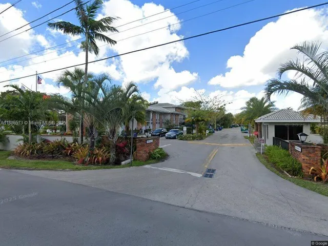a view of a street with potted plants