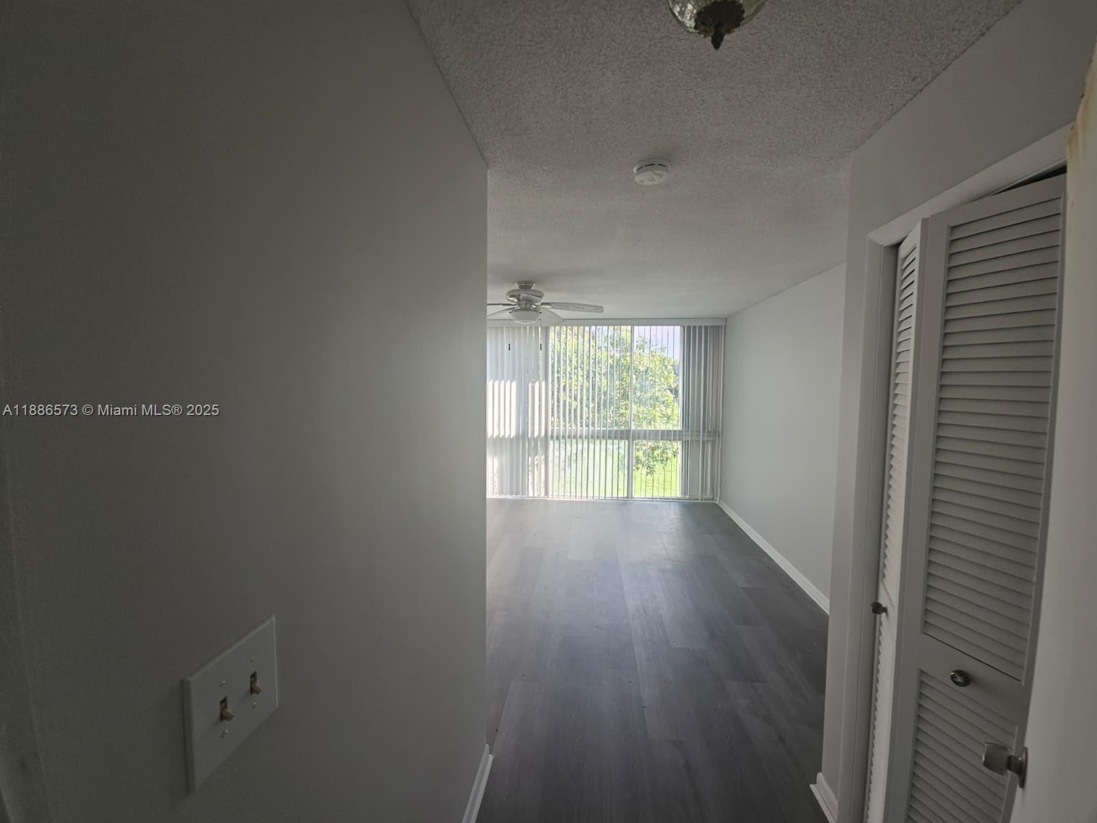6782 Brookline Drive, Unit 6782 Hialeah, FL 33015 - Photo 17 of 27 a view of an empty room with wooden floor and a window