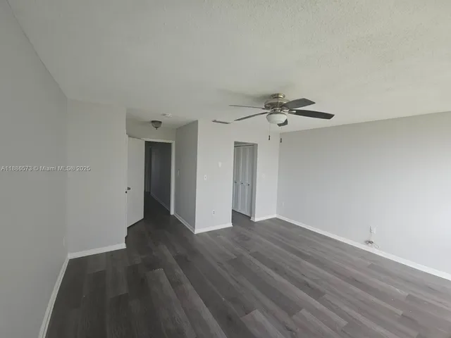 a view of a livingroom with wooden floor and a ceiling fan