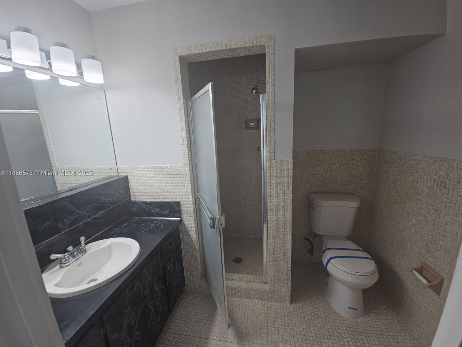 6782 Brookline Drive, Unit 6782 Hialeah, FL 33015 - Photo 19 of 27 a bathroom with a toilet a sink and mirror
