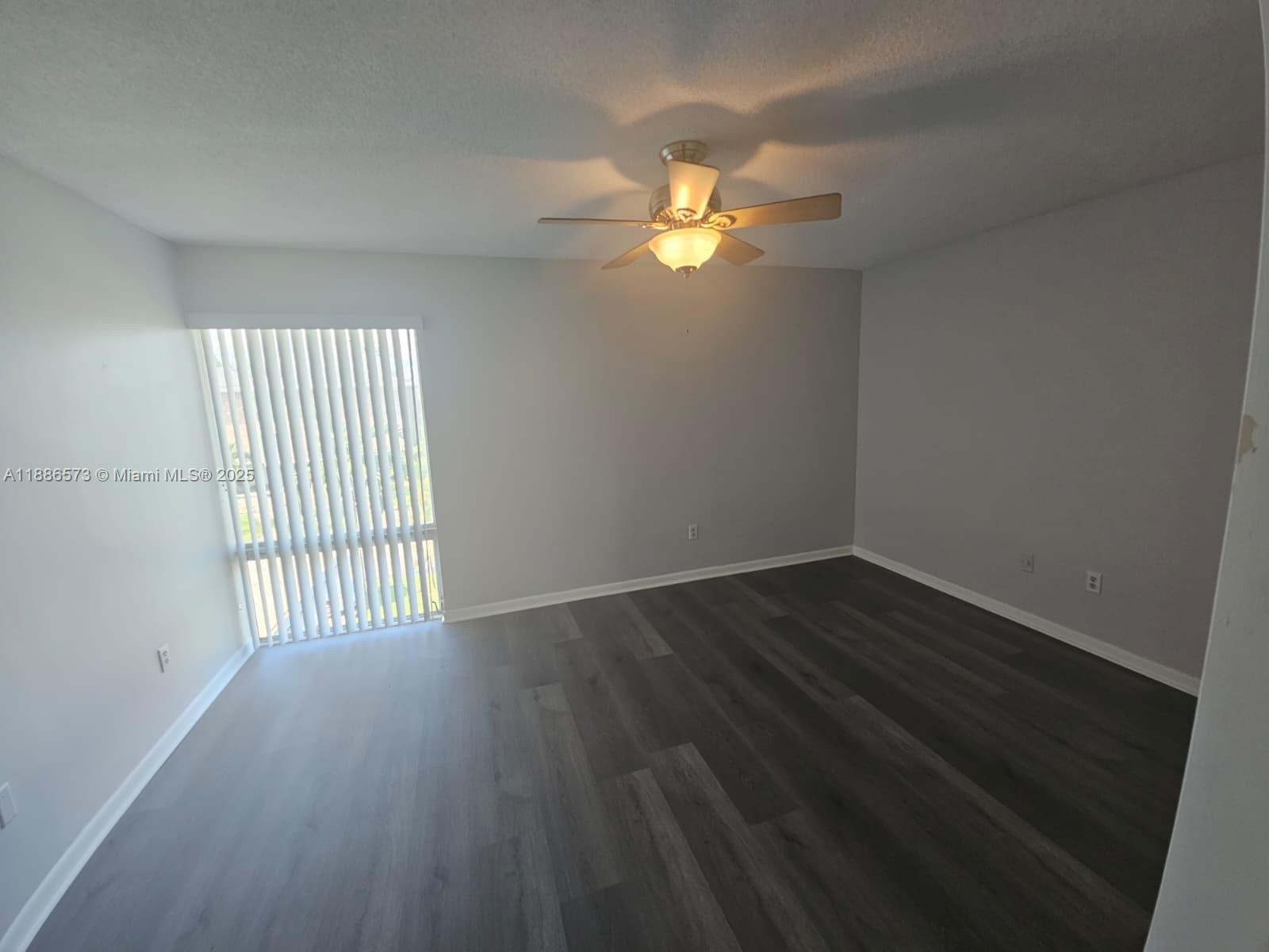 6782 Brookline Drive, Unit 6782 Hialeah, FL 33015 - Photo 21 of 27 an empty room with wooden floor and windows