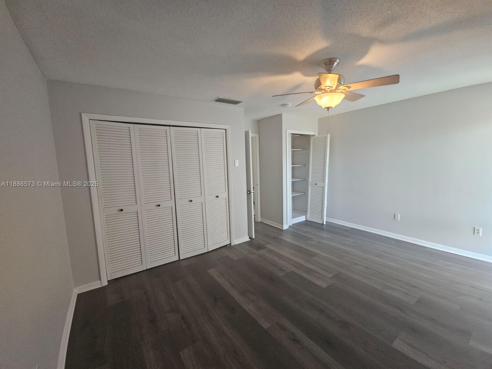 6782 Brookline Drive, Unit 6782 Hialeah, FL 33015 - Photo 22 of 27 a view of a bedroom with wooden floor and a ceiling fan