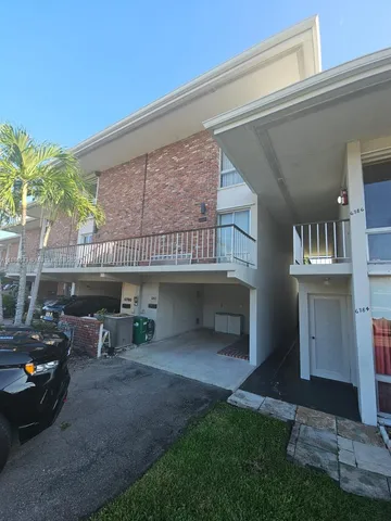 a view of a house with a patio and a yard