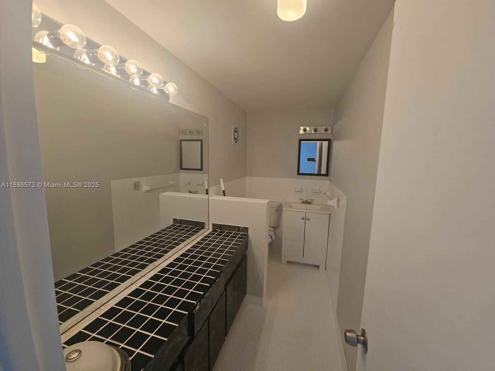 6782 Brookline Drive, Unit 6782 Hialeah, FL 33015 - Photo 10 of 27 a bathroom with a sink toilet and mirror