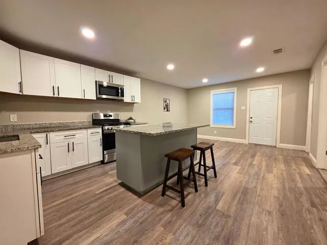 a kitchen with a sink a microwave and cabinets