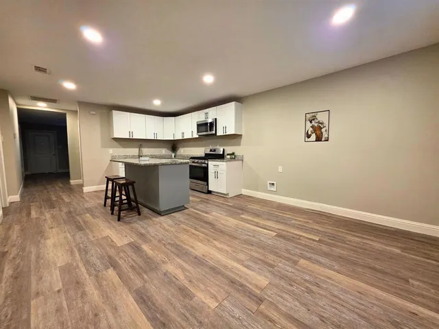 an open kitchen with a sink and breakfast area