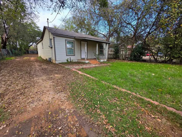 a view of a house with backyard and trees
