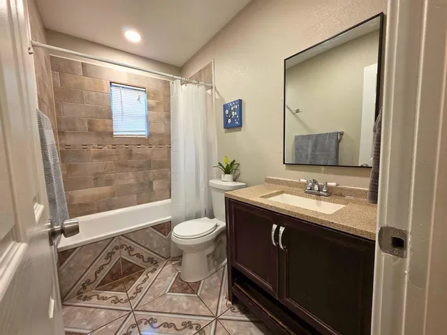 a bathroom with a sink toilet a mirror and shower