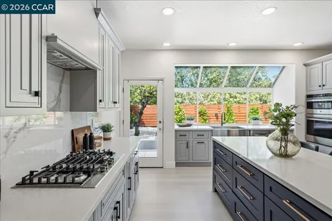 a kitchen with stainless steel appliances a sink stove and window