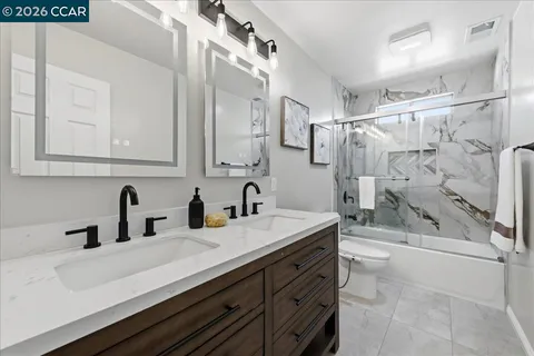 a bathroom with a double vanity sink mirror and shower