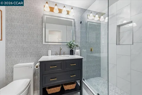 a bathroom with a granite countertop sink toilet and shower