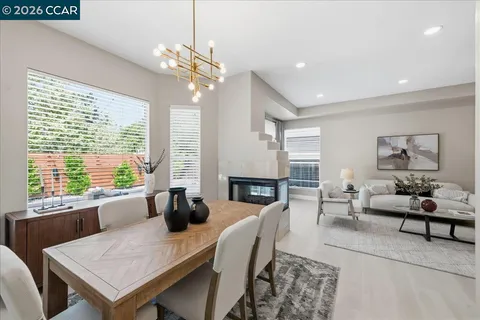 a living room with furniture a fireplace and large windows