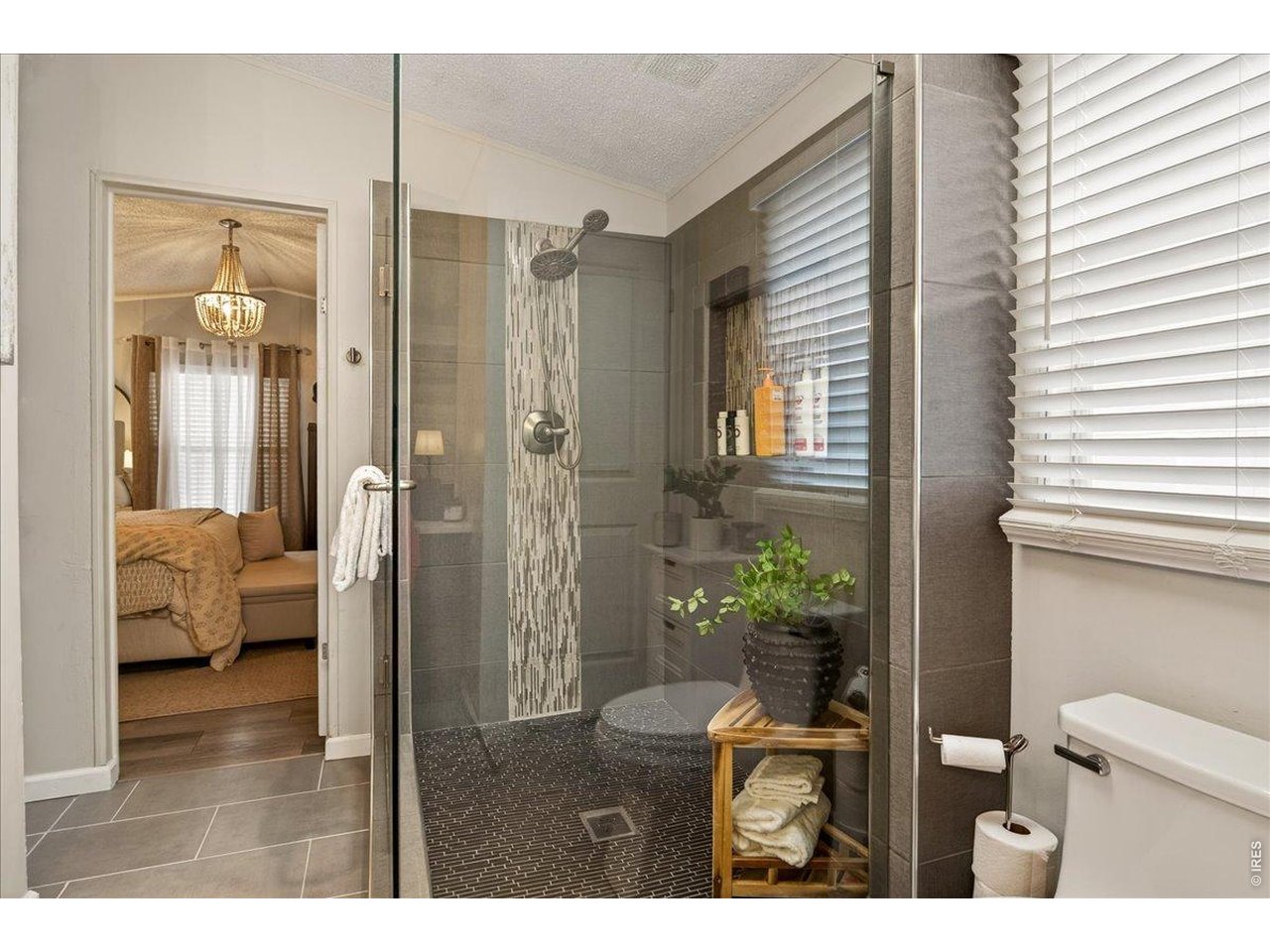 8410 Madison Way Denver, CO 80229 - Photo 14 of 40 Primary bathroom with elegant glass-enclosed walk-in shower.