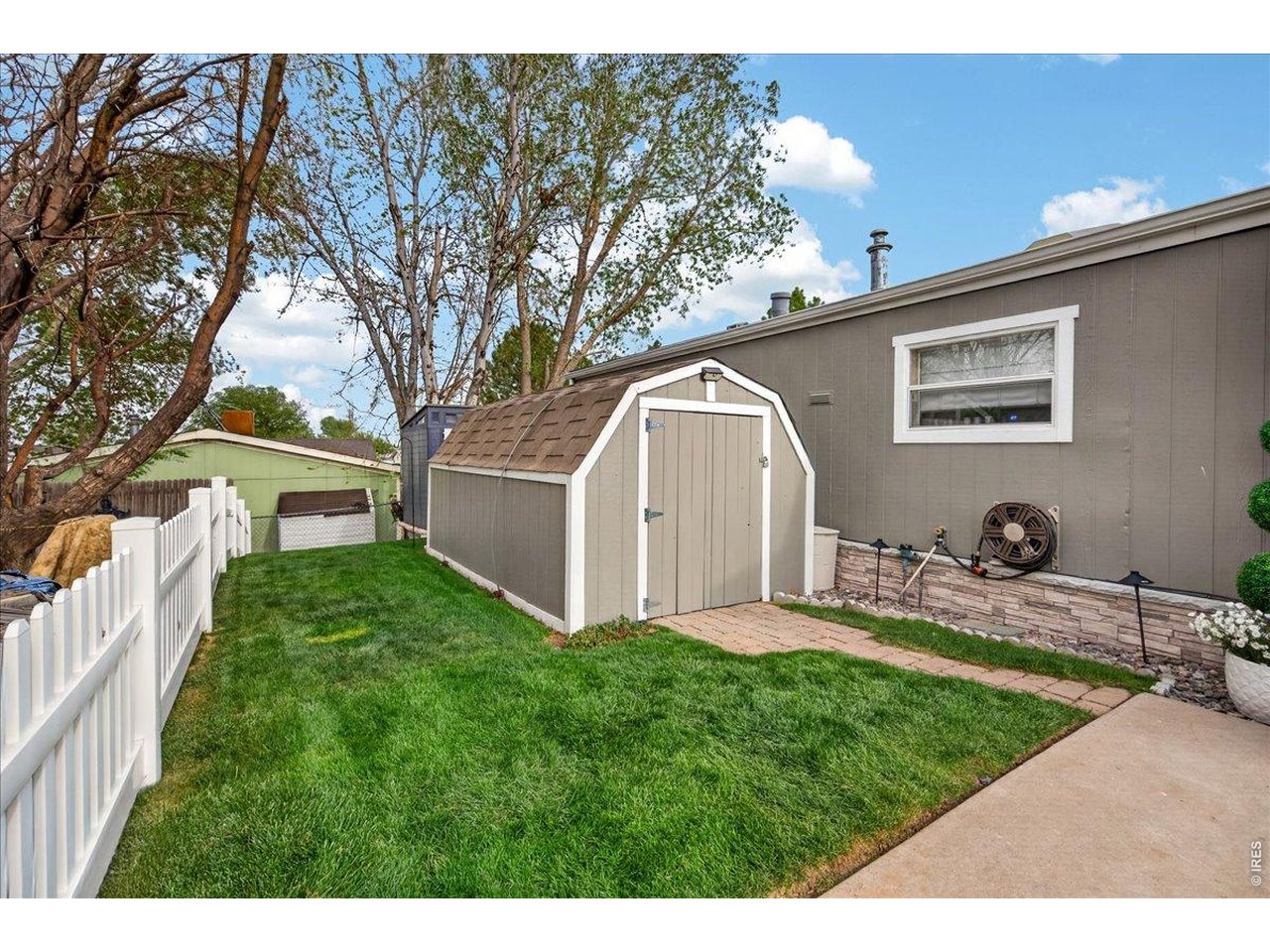 8410 Madison Way Denver, CO 80229 - Photo 30 of 40 The exterior is enhanced by a charming white vinyl fence and well-maintained landscaping.