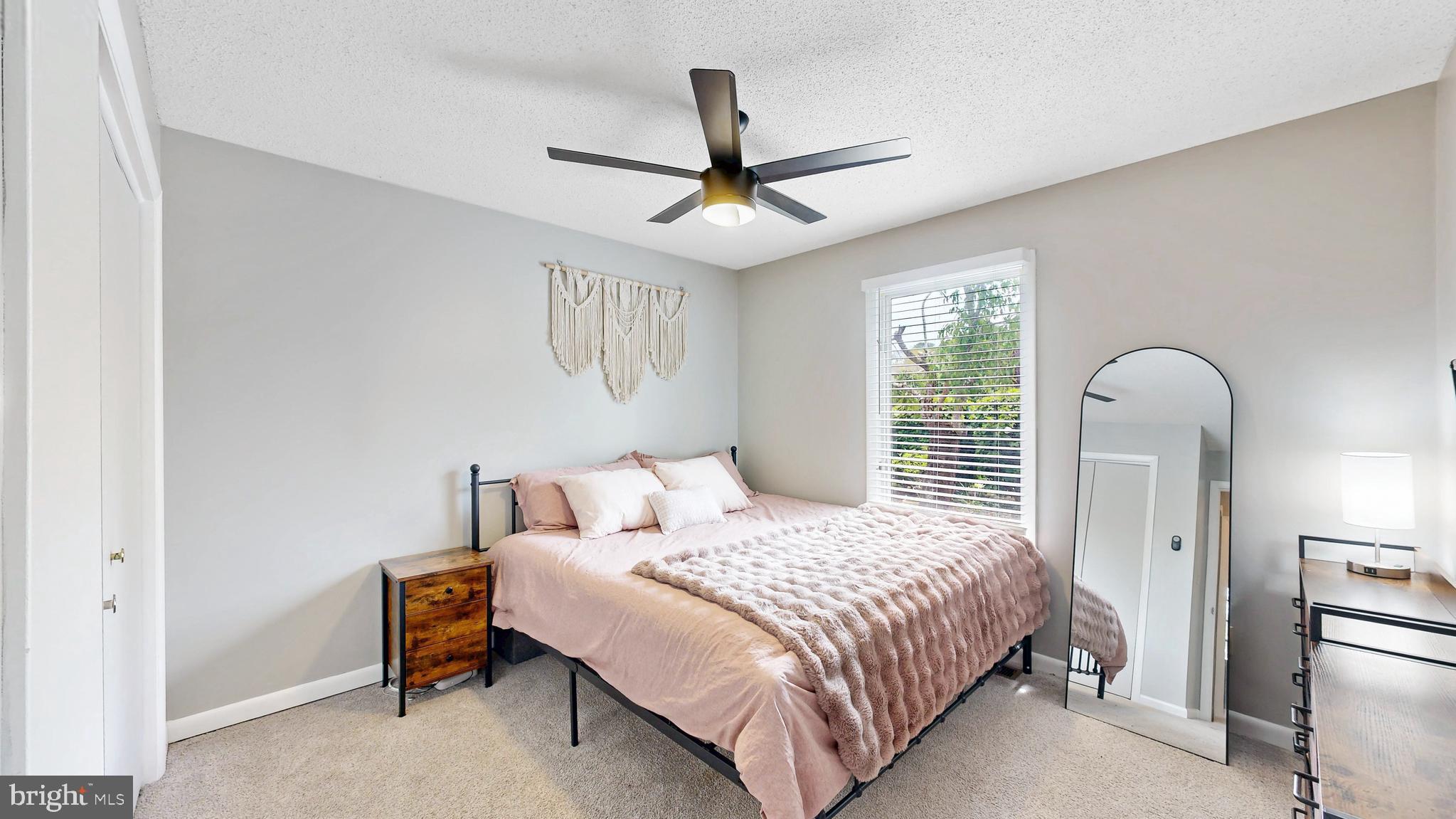 18540 Drayton Hall Road, Unit 2 Lewes, DE 19958 - Photo 26 of 38 a bedroom with a bed and a ceiling fan
