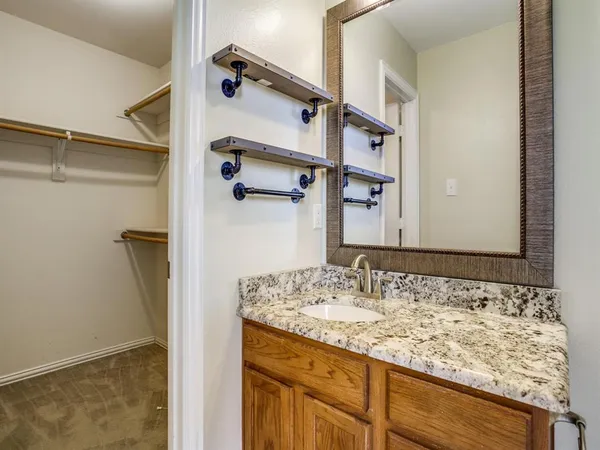a bathroom with a granite countertop sink and a mirror