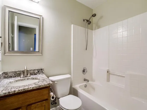 a bathroom with a granite countertop sink toilet and shower
