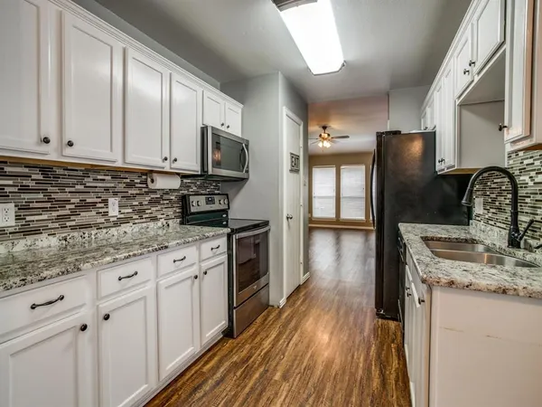 a kitchen with stainless steel appliances granite countertop a stove a sink and a refrigerator