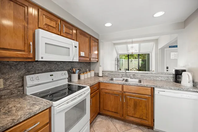 a kitchen with granite countertop a sink stove and cabinets