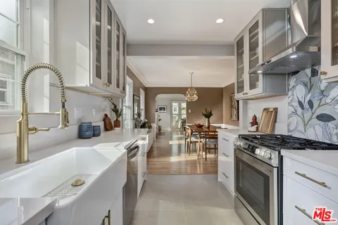 a kitchen with stainless steel appliances granite countertop a sink stove and cabinets