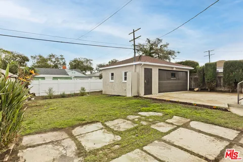a view of a white house with a yard in front and a fountain