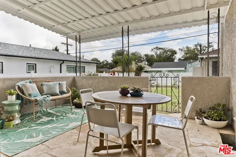 a view of a patio with table and chairs and potted plants
