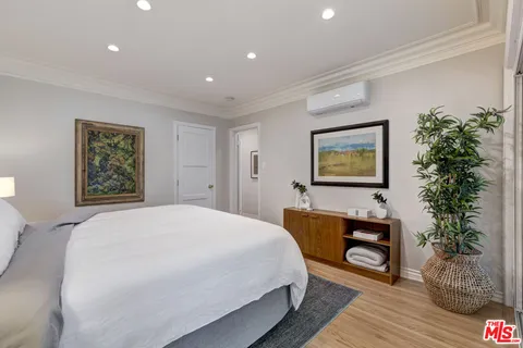 a spacious bedroom with a bed and a potted plant