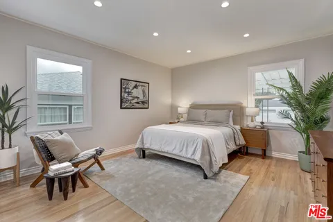 a spacious bedroom with a large bed and a wooden floor