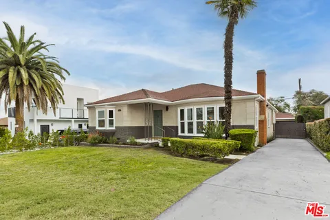 a front view of a house with a garden and yard