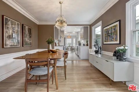 a view of a dining room with furniture a chandelier and wooden floor