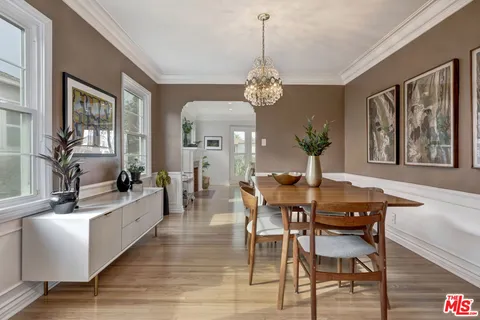 a view of a dining room with furniture a chandelier and wooden floor