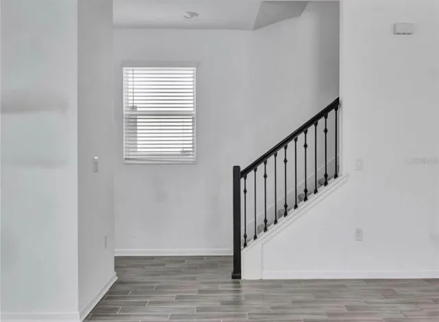 a view of a hallway with wooden floor and staircase