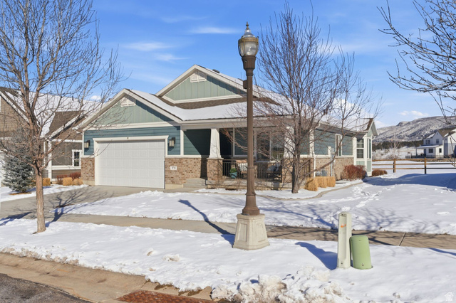 2711 Red Barn Road South Heber City, UT 84032 - Photo 1 of 1 Craftsman inspired home featuring brick siding, a garage, a porch, and a mountain view