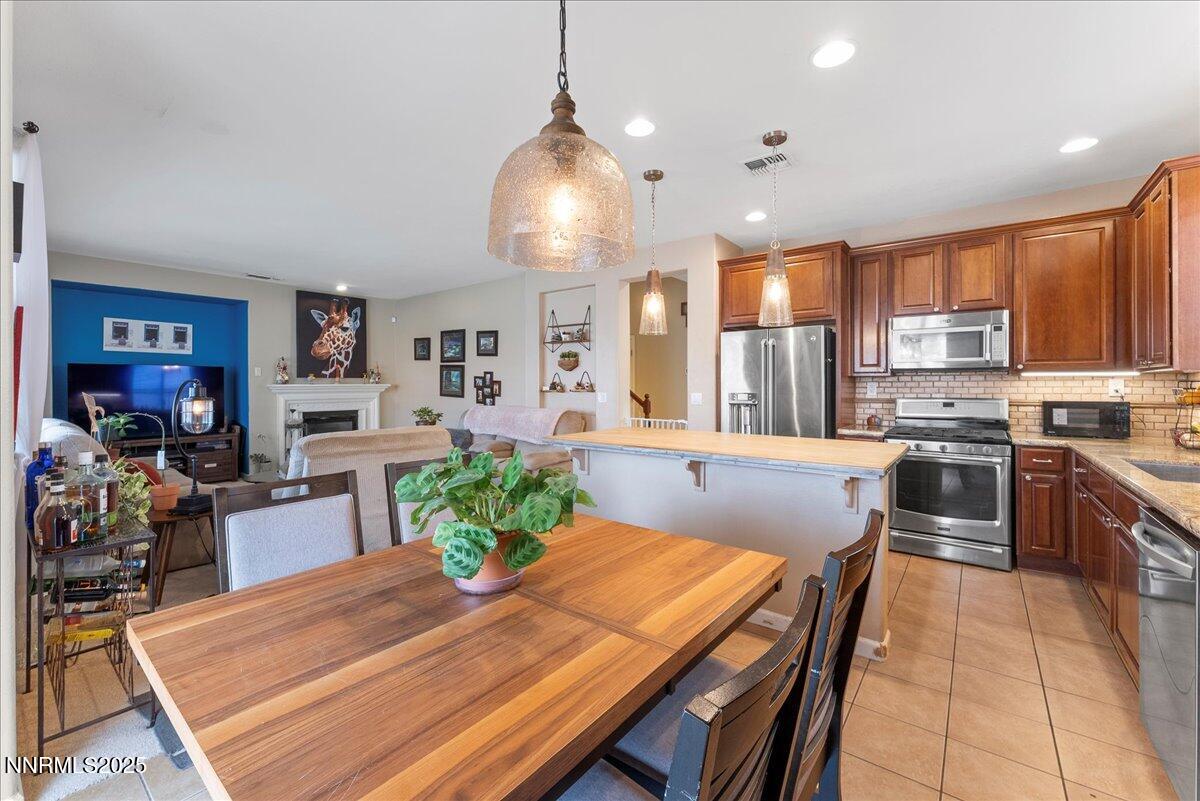 10755 Copper Lake Drive Reno, NV 89521 - Photo 13 of 40 a kitchen with sink refrigerator dining table and chairs