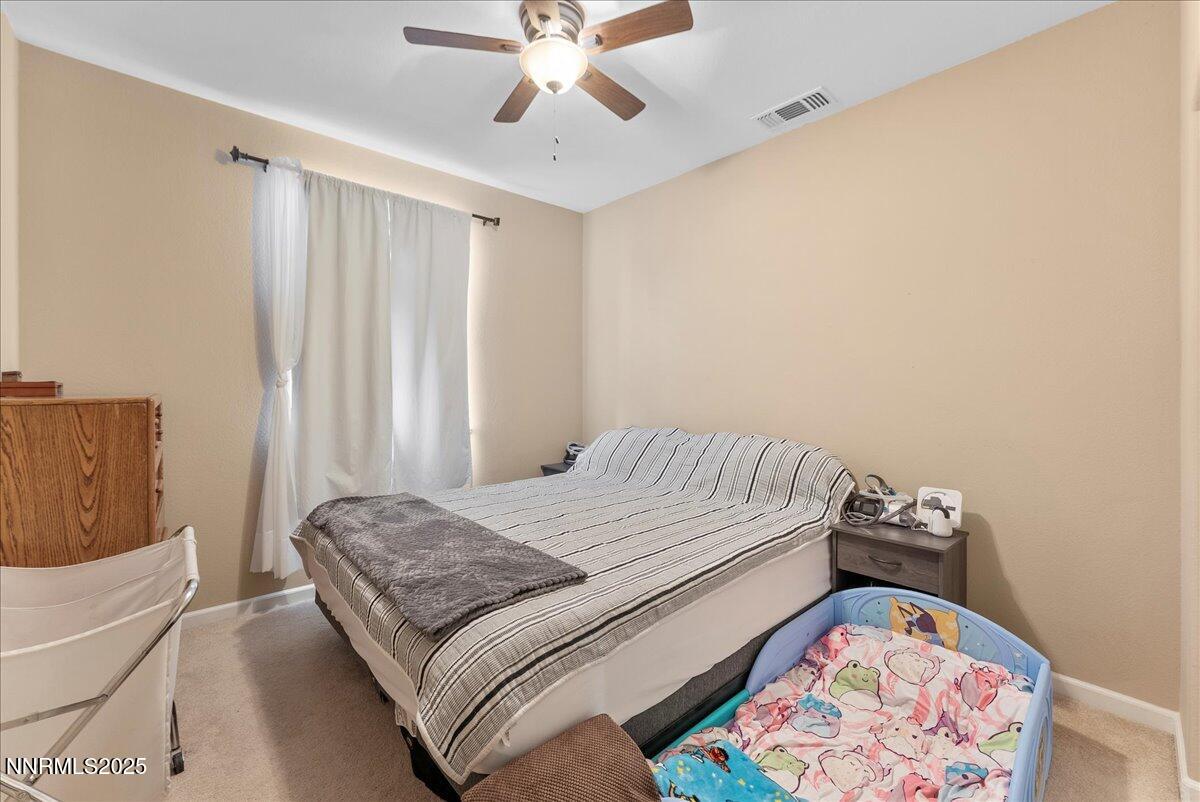 10755 Copper Lake Drive Reno, NV 89521 - Photo 20 of 40 a bedroom with a bed and a chandelier