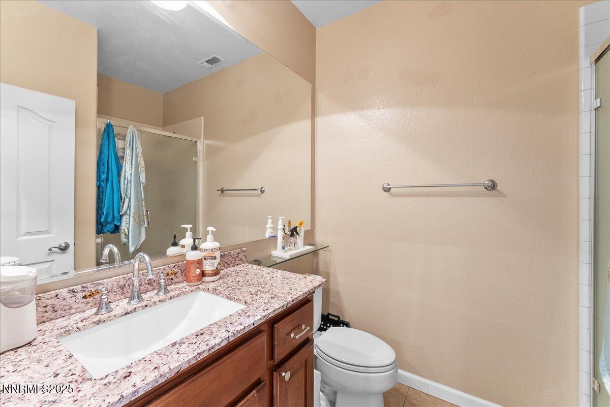 10755 Copper Lake Drive Reno, NV 89521 - Photo 25 of 40 a bathroom with a granite countertop sink a toilet and a mirror