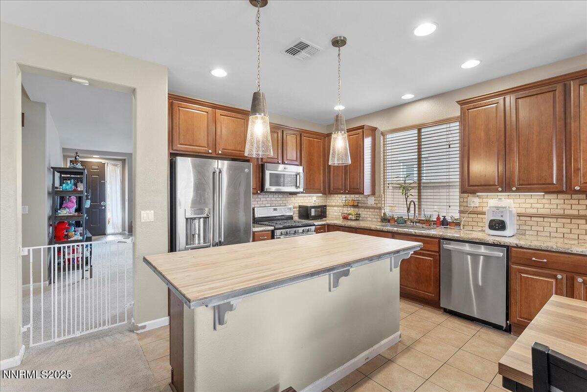 10755 Copper Lake Drive Reno, NV 89521 - Photo 8 of 40 a kitchen with stainless steel appliances granite countertop a sink a stove and a refrigerator