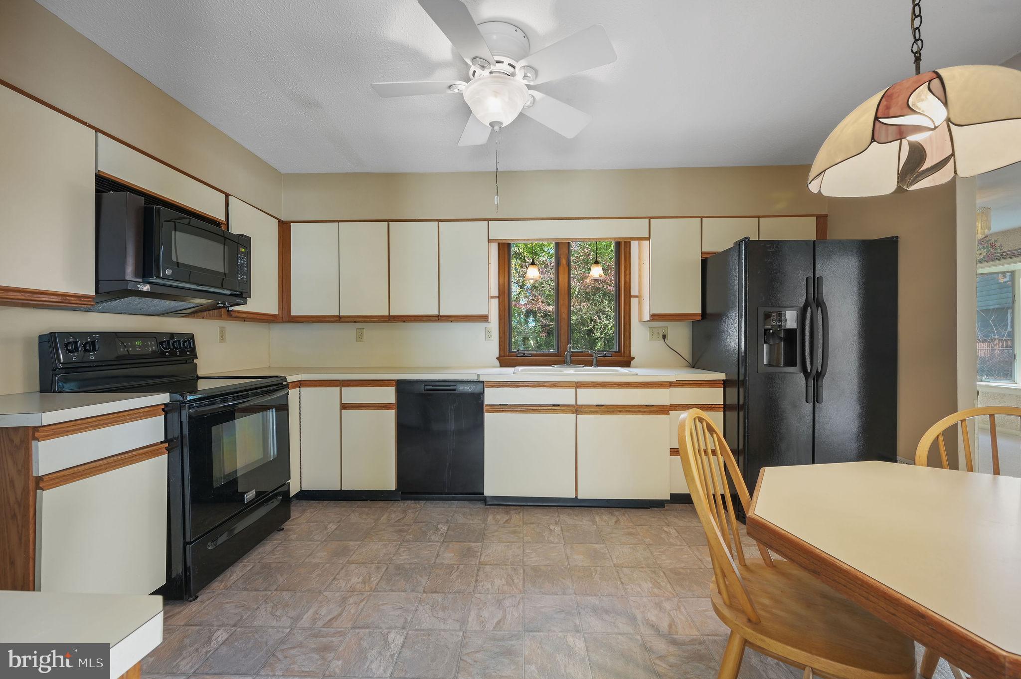 210 Cambridge Road Camden Wyoming, DE 19934 - Photo 6 of 35 a white kitchen with stainless steel appliances granite countertop a sink dishwasher a stove top oven a refrigerator with island and chairs