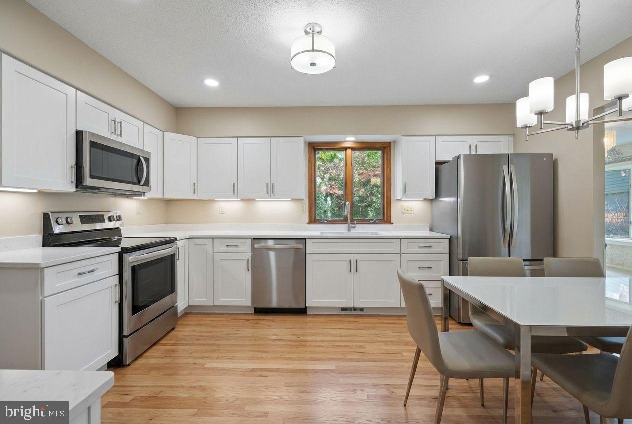 210 Cambridge Road Camden Wyoming, DE 19934 - Photo 8 of 35 a kitchen with stainless steel appliances granite countertop a stove a sink a microwave a refrigerator white cabinets and wooden floor