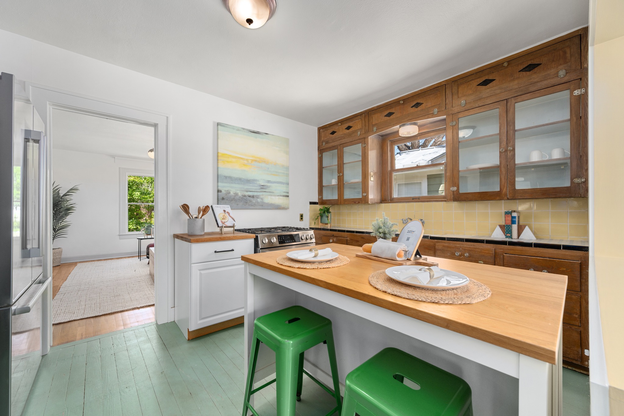 3909 Becker Avenue Austin, TX 78751 - Photo 12 of 38 Kitchen featuring wooden counters, glass insert cabinets, stainless steel appliances, a breakfast bar, and a center island